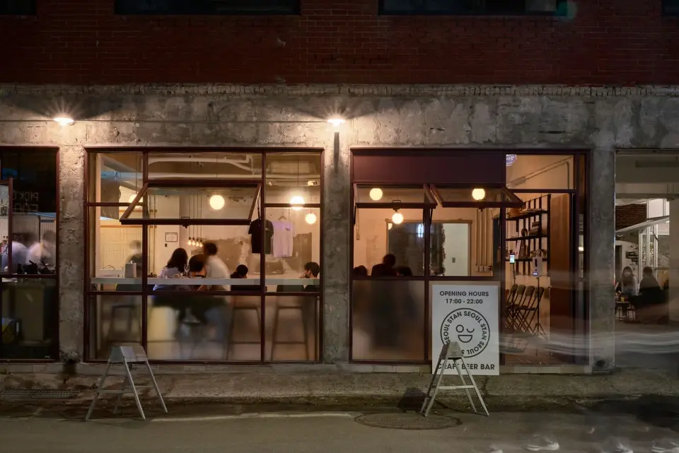 大きな窓と立て看板が見える夜の店舗外観